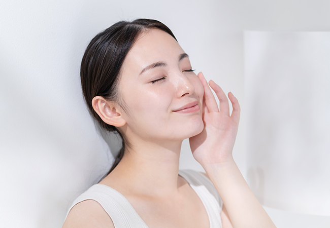 頬に手を添えてほほ笑む女性